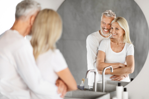 Elderly couple smiling inside their new easy-access shower in Hampshrie and West Sussex, showcasing thoughtful design for senior living.